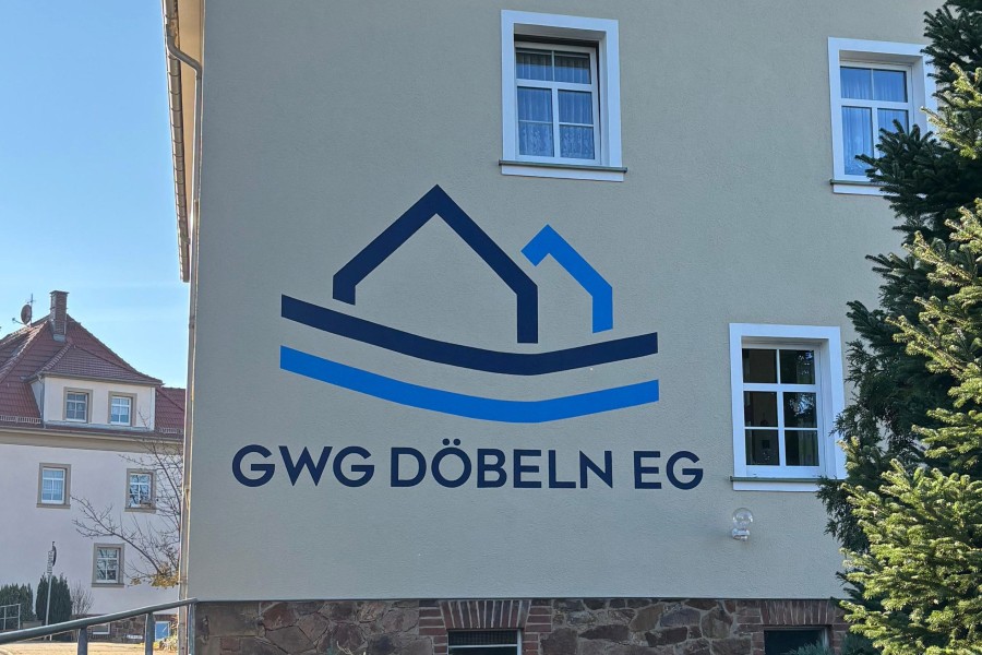 Wohngebäude mit Logo blau-türkis der GWG Döbeln eG auf der Fasade