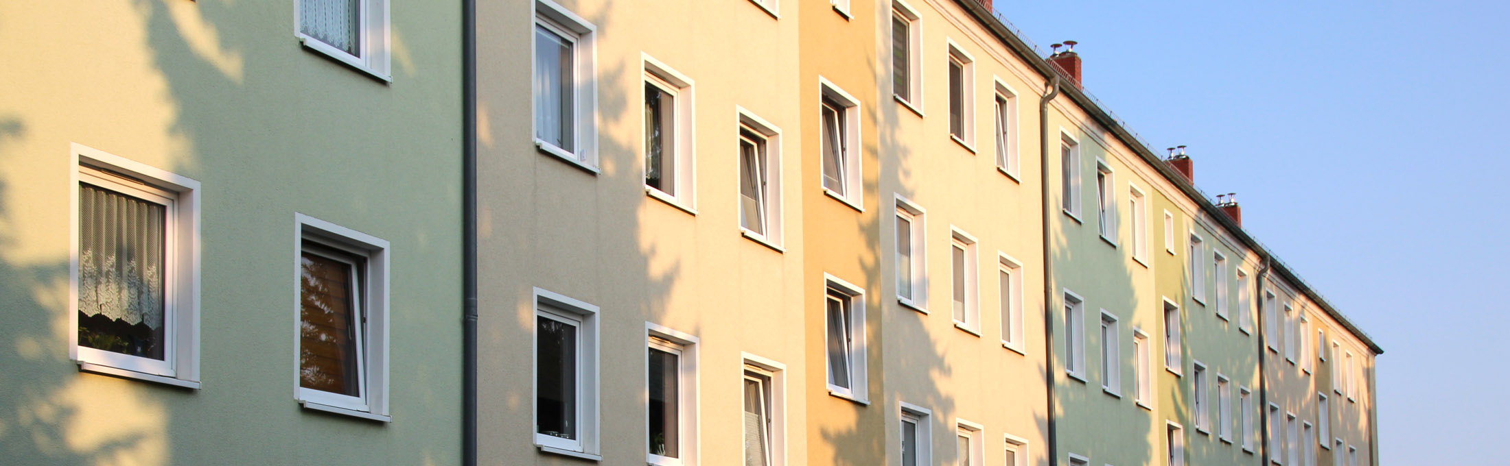 Fassade mit Fensterreihen eines mehrstöckigen Wohngebäudes.